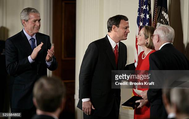 John Roberts, center, kisses his wife Jane after he was sworn in as the 17th chief justice of the United States by Supreme Court Associate Justice...