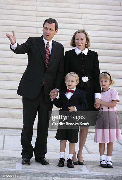 Supreme Court Chief Justice John Roberts, left, stands in front of the U.S. Supreme Court building with his wife Jane, daughter Josie, front right,...