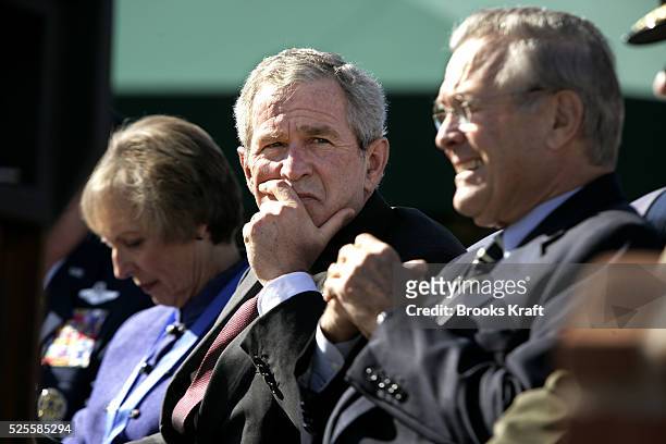 President George W. Bush, center, and Secretary of Defense Donald Rumsfeld, right, watch a flyover during an Armed Forces farewell tribute in honor...