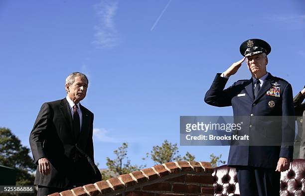 President George W. Bush, left, arrives to participate in the Armed Forces Farewell Tribute in Honor of General Richard B. Myers, right, and Armed...