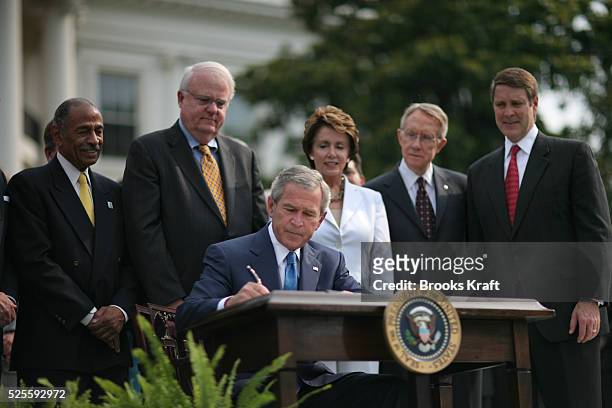 President George W Bush signs the Voting Rights Act of 2006 during a ceremony on the South Lawn of the White House in Washington, July 27, 2006....