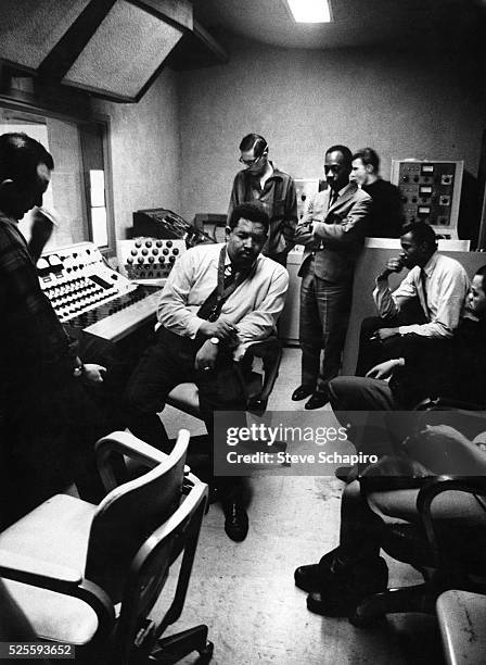 Cannonball Adderly, Bill Evans and others listening to a recording at a studio