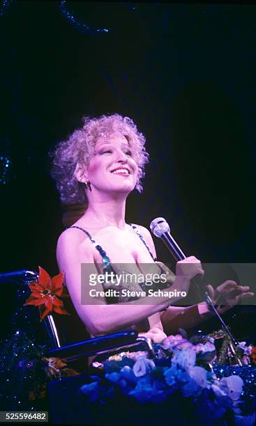 American singer-songwriter, actress and comedian Bette Midler on stage in a scene from her concert film 'Divine Madness,' directed by Michael...
