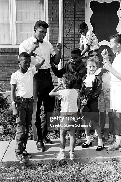 Muhammad Ali with neighborhood kids outside his mother's house in Louisville, Kentucky, including Yolanda "Lonnie" Williams who would become his wife...