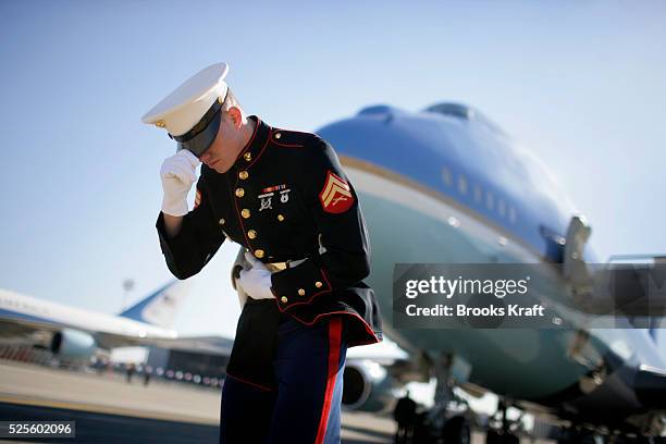 Marine holds onto his hat as Marine One lands next to Air Force One at Ben Gurion International Airport in Tel Aviv, Israel.