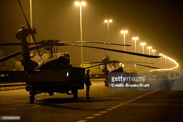 Marines wait for the arrival of U.S. President George W. Bush as two Marine One helicopters are parked on a closed-off road near Sowaihan in the...