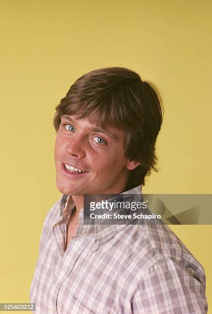 American actor Mark Hamill wearing a check shirt in a studio portrait, against a yellow background, circa 1975.