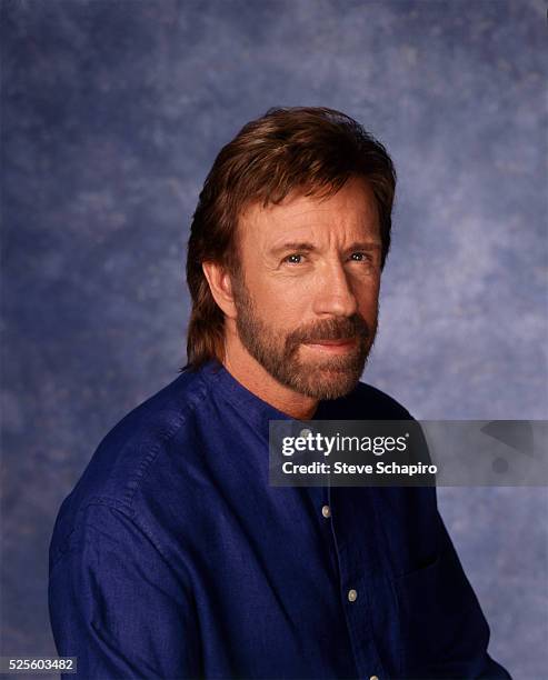 American martial artist and actor Chuck Norris wearing a blue collarless shirt in a studio portrait, circa 1980.