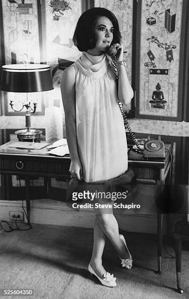 Russian-American actress Natalie Wood wearing a rollneck shift dress with a fur hem, by designer Arnold Scaasi, speaking on the telephone, circa 1965.