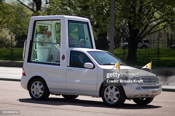 Pope Benedict XVI waves from the popemobile as he drives in front of the White House in Washington.