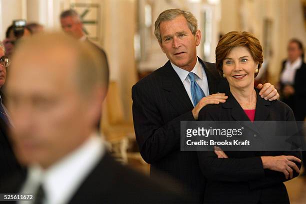 United States President George W. Bush and First Lady Laura Bush watch Russian President Vladimir Putin talk to the press during a tour of the...