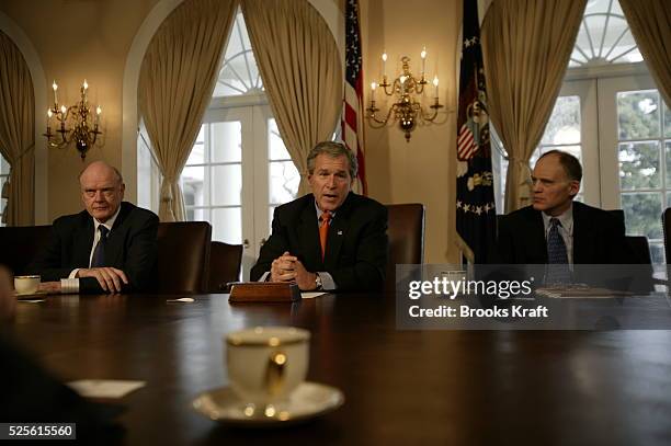 Surrounded by members of his National Economic Council, President George W. Bush makes a point while speaking to reporters about Iraq in the Cabinet...