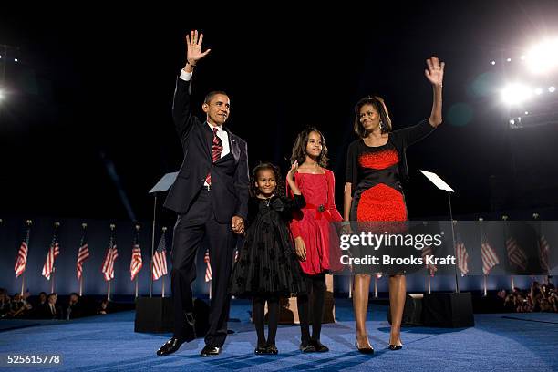 President-elect Barack Obama, left, his wife Michelle Obama, right, and two daughters, Malia, and Sasha, center left, wave to the crowd at the...
