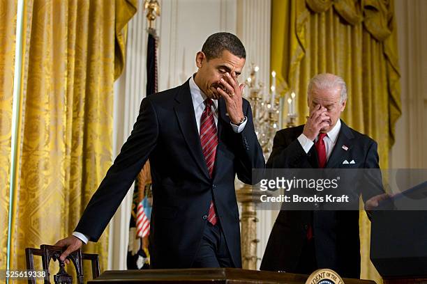 President Barack Obama prepares to sign the Middle Class Working Families Task Force executive order, as Vice President Joe Biden watches, in the...