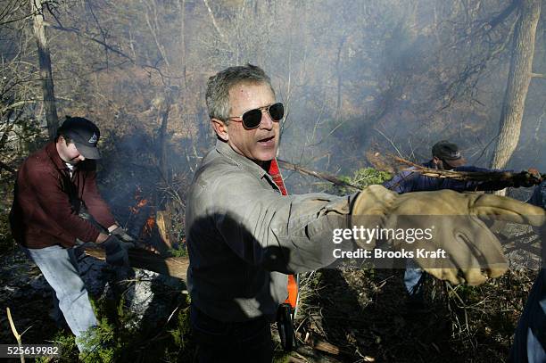 President George W. Bush clears and burns cedar underbrush on the Bush Ranch in Crawford, Texas. In the dry climate, the cedar absorbs a significant...