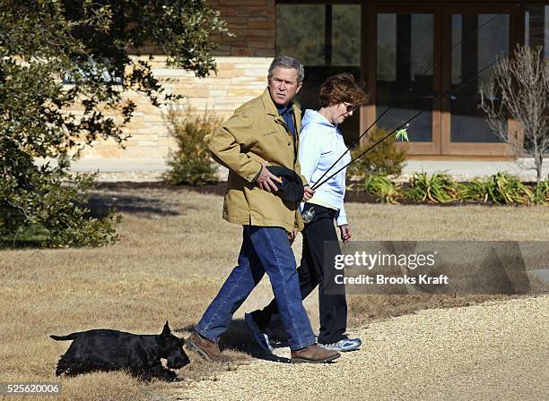 President George W. Bush heads off for a walk with his wife and First Lady, Laura Bush and dog Barney from their home on the Bush Ranch in Crawford,...