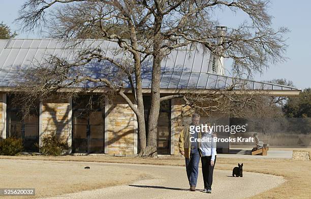 President George W. Bush walks with his wife and First Lady, Laura Bush and dog Barney from their home on the Bush Ranch in Crawford, Texas.