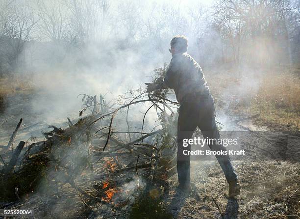 President George W. Bush clears and burns cedar underbrush on the Bush Ranch in Crawford, Texas. In the dry climate, the cedar absorbs a significant...