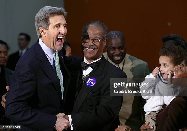 Democratic presidential hopeful Senator John Kerry of Massachusetts laughs with supporters at the end of a news conference upon his arrival to...