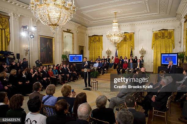 President Barack Obama takes part in an Internet online virtual town hall meeting in the East Room of the White House in Washington.