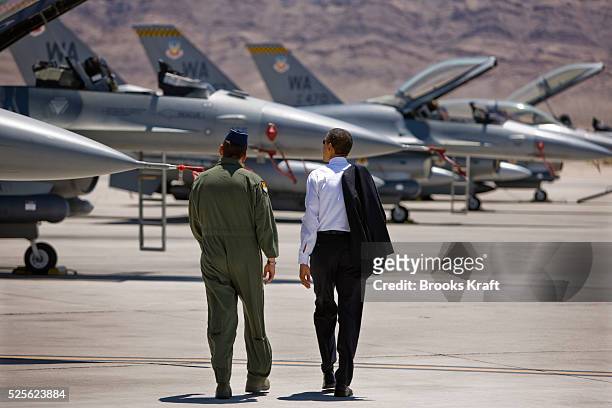 President Barack Obama walks past F-16 aircraft with Brigadier General Stanley Ted Kresge at Nellis Air Force Base in Las Vegas, Nevada. Photo by...