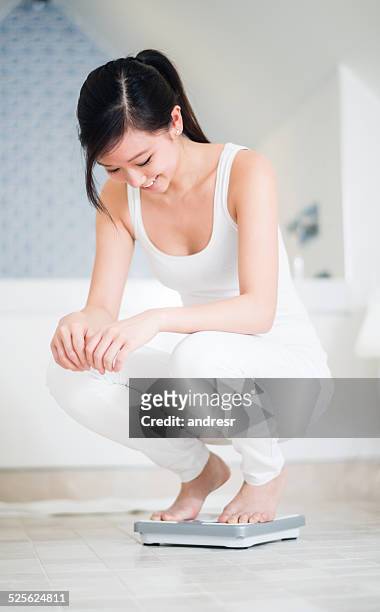 woman checking her weight - mass unit of measurement stock pictures, royalty-free photos & images