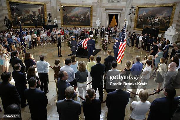 People file past the casket of former U.S. President Ronald Reagan as he lies in state inside the rotunda of the U.S. Capitol in Washington....