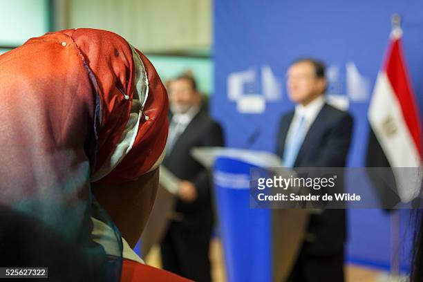 Journalist with an orange head scarf listens to European Commission President Jose Manuel Barroso, right, and the Egyptian President Mohamed Morsi...