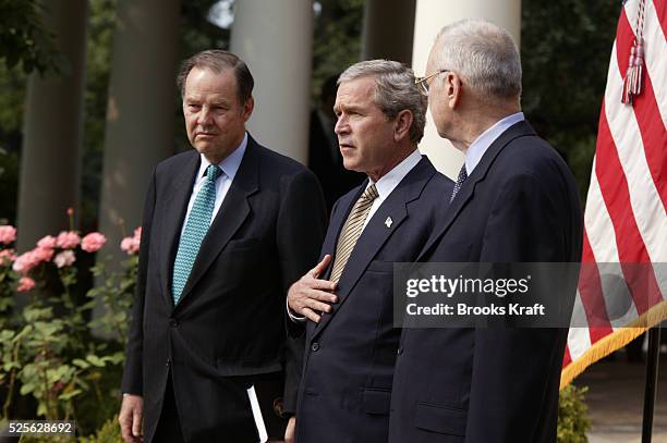 President George W. Bush receives the September 11th Commission report from commission members Thomas Kean and Lee Hamilton in the Rose Garden of the...