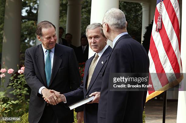 President George W. Bush receives the September 11th Commission report from commission members Thomas Kean and Lee Hamilton in the Rose Garden of the...