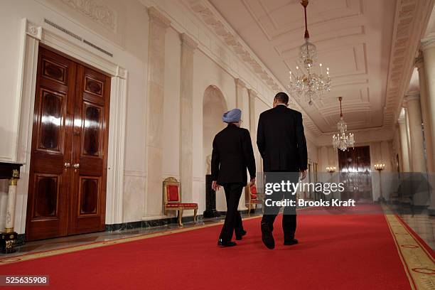 President Barack Obama and Prime Minister Manmohan Singh walk down the Cross Hall on the way to a news conference in the East Room at the White House...