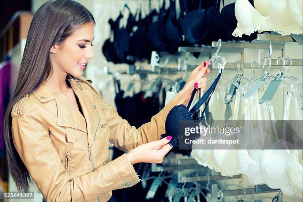 young woman shopping for bra. - beha stockfoto's en -beelden