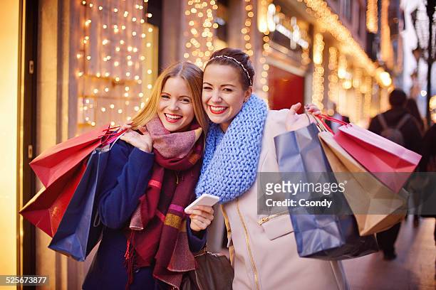 junge frauen mit handy, beim einkaufen - christmas shopping stock-fotos und bilder