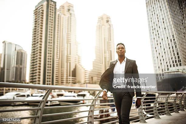 homme d'affaires marchant dans le port de plaisance de dubaï - corporate travel photos et images de collection