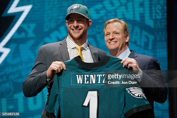 Carson Wentz of the North Dakota State Bison holds up a jersey with NFL Commissioner Roger Goodell after being picked overall by the Philadelphia...