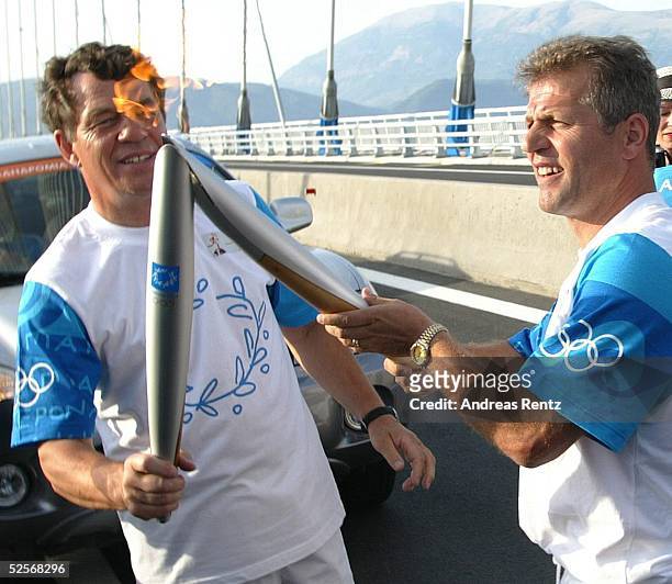 Sport / Olympia: Olympische Spiele Athen 2004, Athen; Fackellauf / Trainer Otto REHHAGEL uebergibt dem Trainer der Griechischen Fussball...
