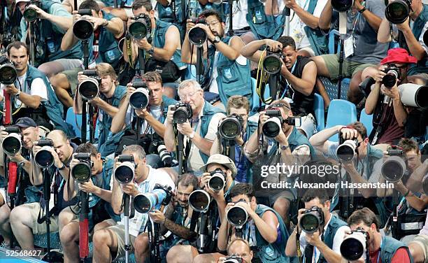 Feature / Medien: Olympische Spiele Athen 2004, Athen; Medien: Fotografen beobachten die Sportlerim Schwimmbecken 14.08.04.