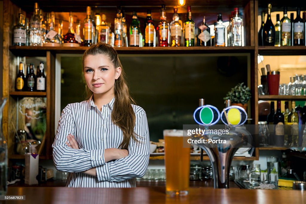 Confident bartender standing in restaurant