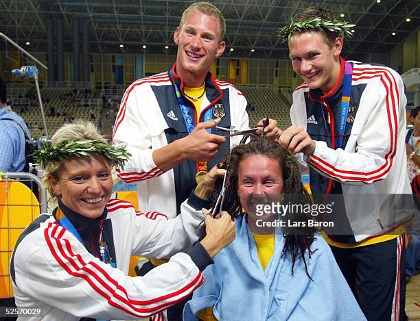 Behindertensport / Schwimmen /: Paralympics 2004, Athen; Die drei Gold - Gewinner Kirsten BRUHN, Christoph BURKHARD und Daniel CLAUSENER schneiden...