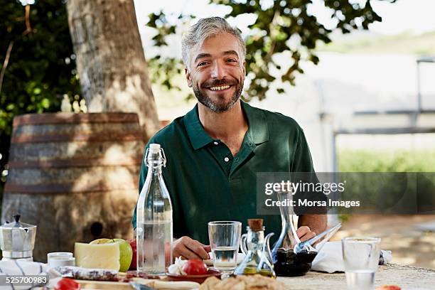 worker sitting at breakfast table in yard - men's water polo stockfoto's en -beelden