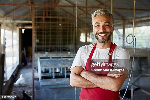 happy worker standing at poultry farm - agricultural occupation - fotografias e filmes do acervo