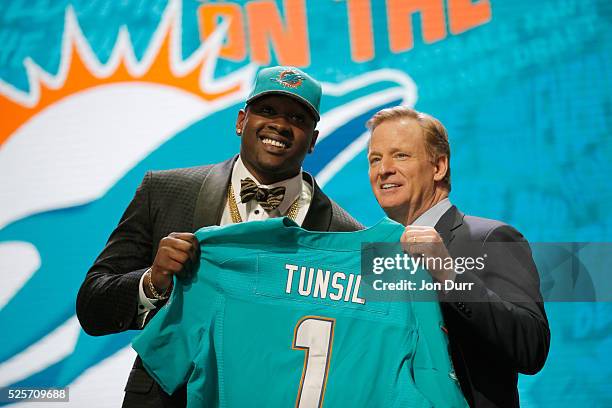 Laremy Tunsil of Ole Miss holds up a jersey with NFL Commissioner Roger Goodell after being picked overall by the Miami Dolphins during the first...