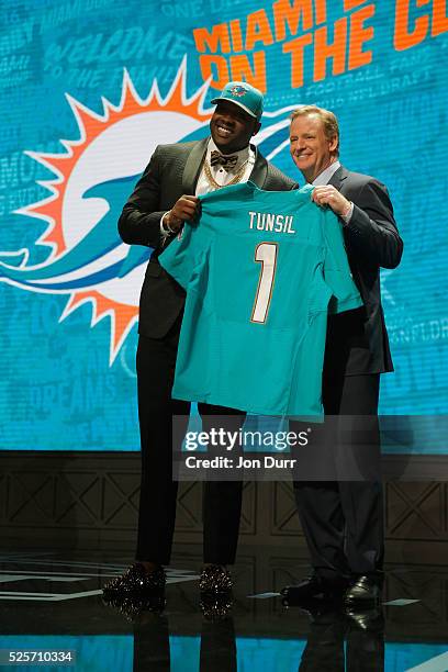 Laremy Tunsil of Ole Miss holds up a jersey with NFL Commissioner Roger Goodell after being picked overall by the Miami Dolphins during the first...