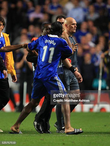 Players try and stop a very angry Didier Drogba of Chelsea from arguing with Referee Tom Henning Ovrebo after he failed to give a penalty in the...
