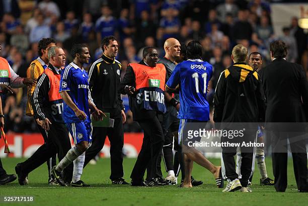 Players try and stop a very angry Didier Drogba of Chelsea from arguing with Referee Tom Henning Ovrebo after he failed to give a penalty in the...