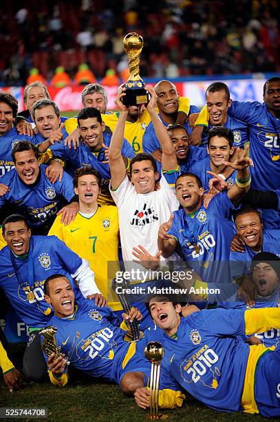 Lucio of Brazil holds up the FIFA Confederations Cup trophy with his team mates celebrating the victory over USA 2-3