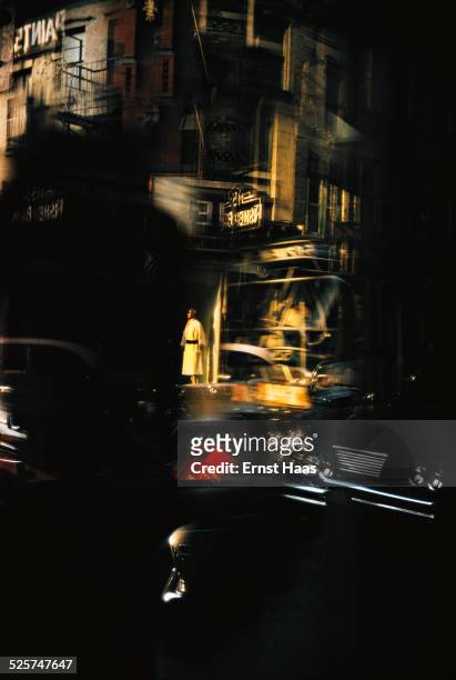 Passing cars and a shop mannequin, reflected in a window, New York, August 1962.