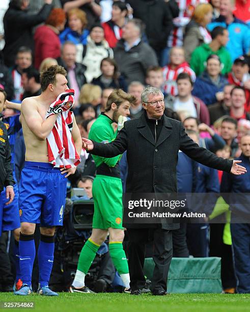 Phil Jones of Manchester United and Sir Alex Ferguson the head coach / manager of Manchester United react after hearing the news that Manchester City...