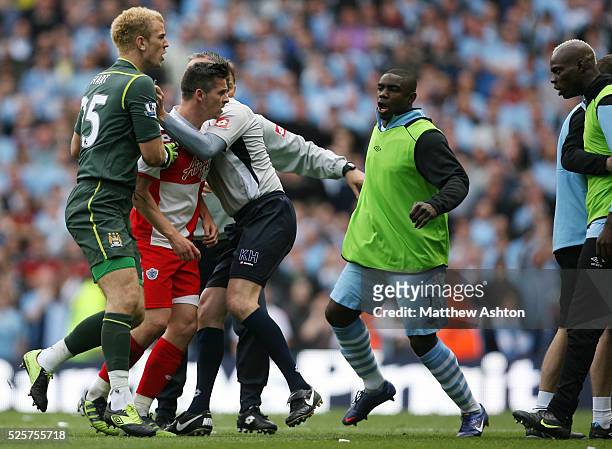 Joe Hart of Manchester City holds back Joey Barton of Queens Park Rangers as he is taunted by Mario Balotelli of Manchester City