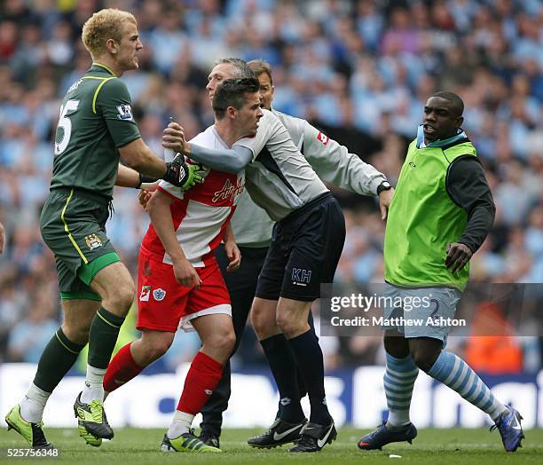 Joe Hart of Manchester City holds back Joey Barton of Queens Park Rangers after he is sent off